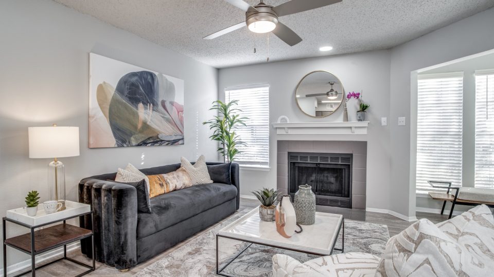 a living room with a fireplace and ceiling fan at The Westley