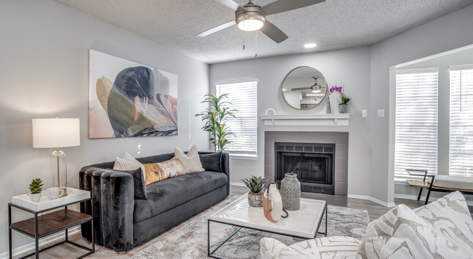 a living room with a fireplace and ceiling fan at The Westley
