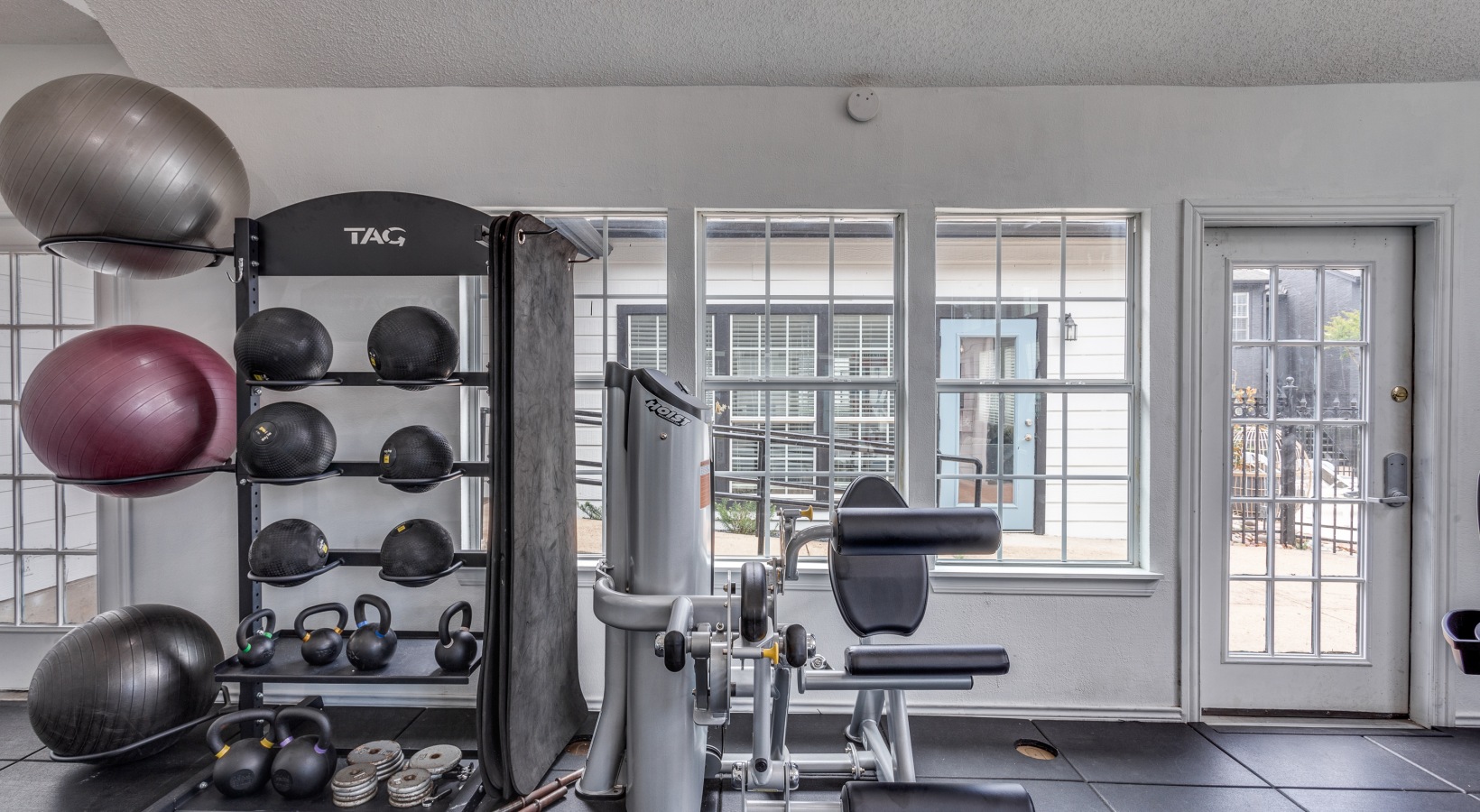 a gym room with weights, exercise equipment and a mirror at The Westley