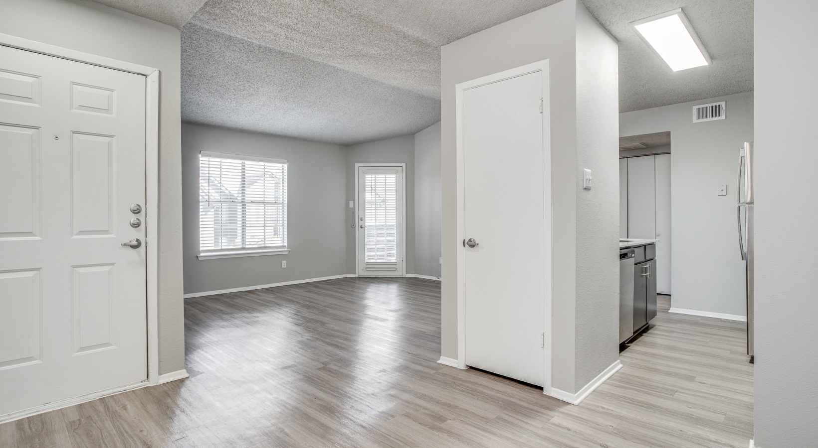 an empty room with white walls and hardwood floors at The Westley