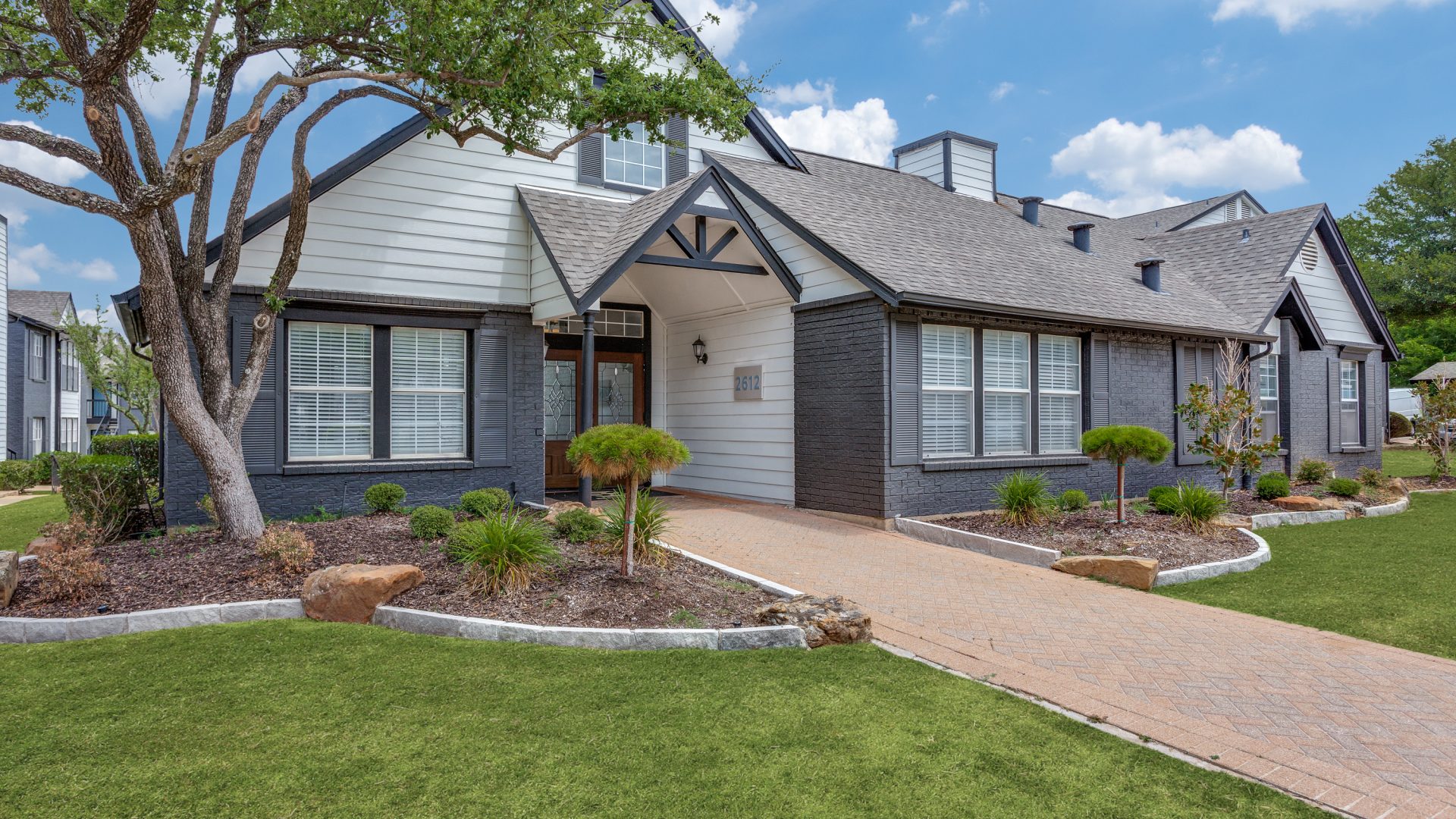 a home with a driveway and landscaping at The Westley