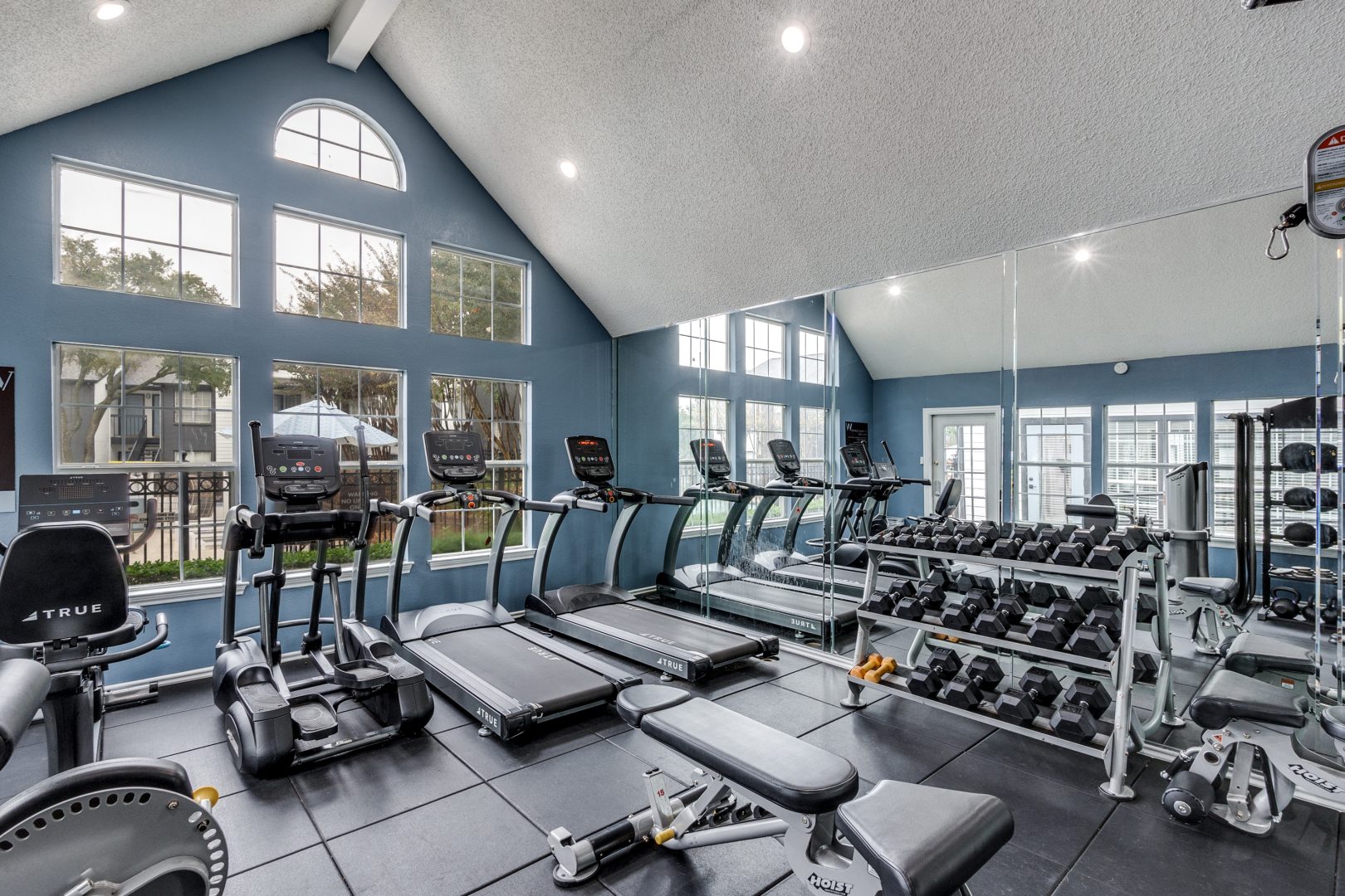 a gym room with exercise equipment and windows at The Westley